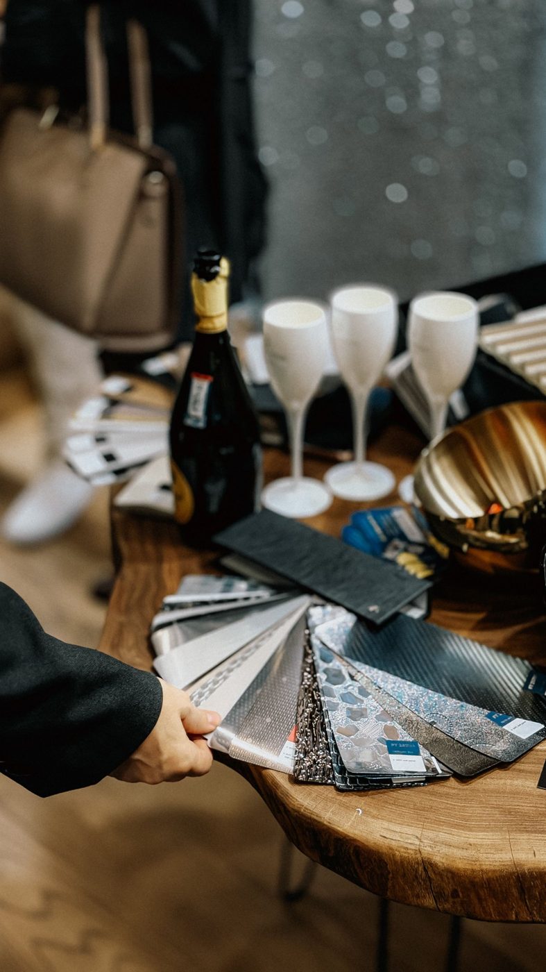 Nuancier d'échantillons métalliques et texturés déployé en éventail sur une table en bois massif